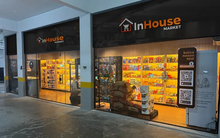 Loja InHouse Market em espaço coberto, com prateleiras de produtos e totem de autoatendimento